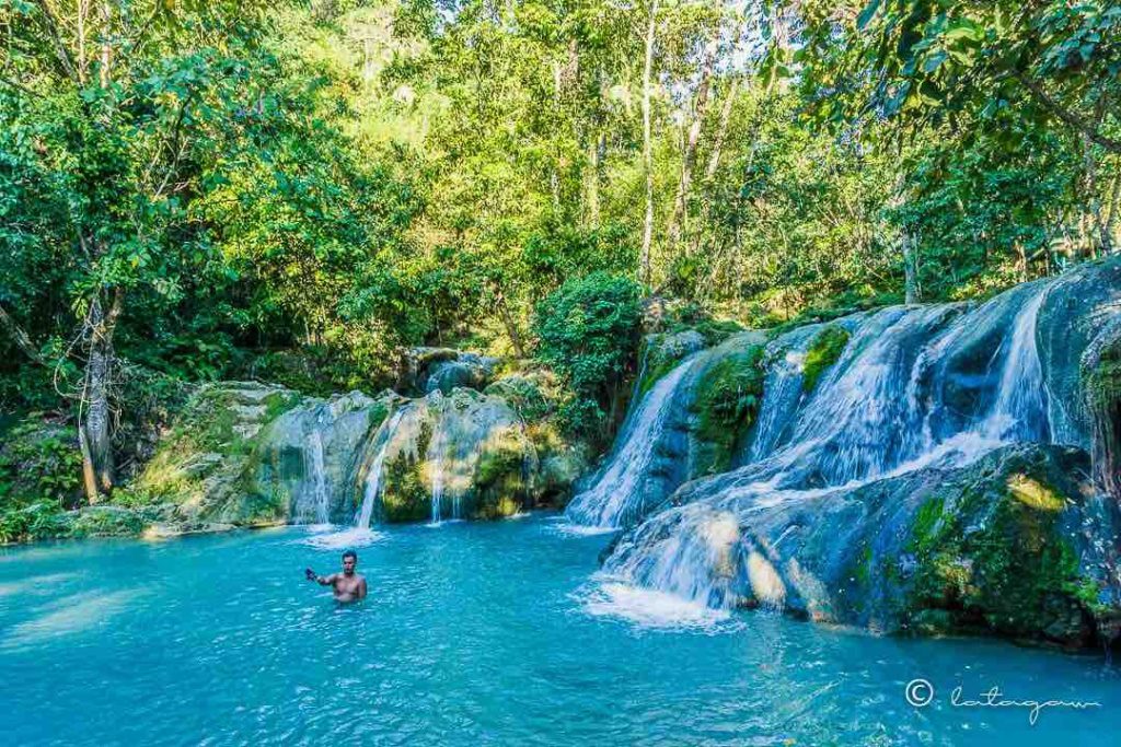 man swimming in hagimit falls located in island garden city of samal davao del norte
