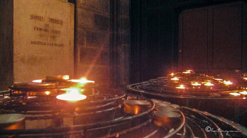 lighting of candles inside notre dame cathedral paris france