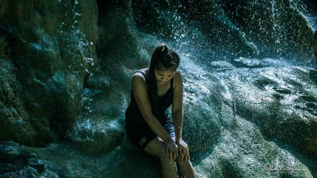 woman relaxing under the waterfalls